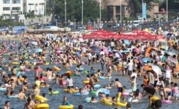 多地遭遇高温天——青岛海滨浴场成“人海”
