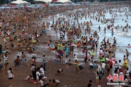 青岛第一浴场游客爆满 扎堆场面如同“下饺子”