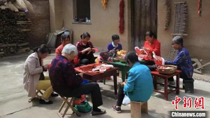 图为李惠莲和邻里妇女们一起制作刺绣工艺品。　受访者供图