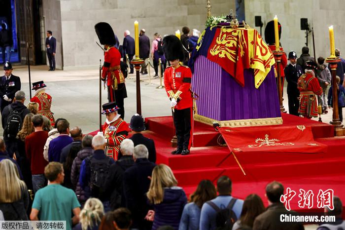 当地时间2022年9月18日，英国女王伊丽莎白二世在伦敦威斯敏斯特大厅举行灵柩瞻仰仪式，皇家警卫站在她的灵柩旁，公众向她表示敬意。